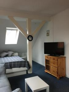 a living room with a flat screen tv and a couch at Altes Zollhaus in Borkum