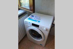 uma máquina de lavar roupa numa casa de banho ao lado de uma janela em Casa Vacanze LILIANA em Priocca