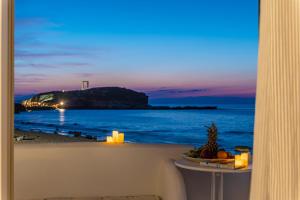 a view of the beach from a balcony with candles at Grotta Sognare in Naxos Chora