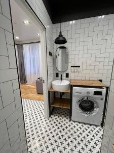 a bathroom with a washing machine and a sink at Poetry Apartments in the city center in Kharkiv