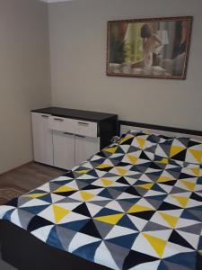 ノヴォロシースクにあるгостевой домのベッドルーム1室(青と黄色の掛け布団付きのベッド1台付)