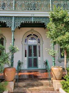 a front door of a house with two potted trees at Anglesey House Iconic Forbes CBD Heritage Home in Forbes