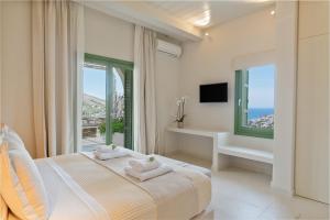 Schlafzimmer mit einem Bett und Meerblick in der Unterkunft Casa Di Fiori Andros Suites in Ándros
