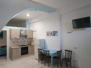 a kitchen with a blue table and chairs in it at Casa in borgo marinaro in Giardini Naxos