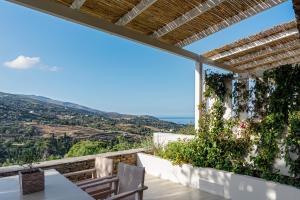 z balkonu domu ze stołem i krzesłami w obiekcie Casa Di Fiori Andros Suites w mieście Andros