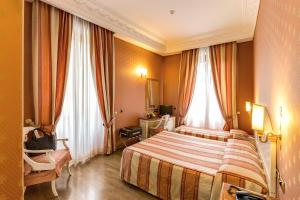 a hotel room with a bed and two windows at Hotel La Lumiere Di Piazza Di Spagna in Rome