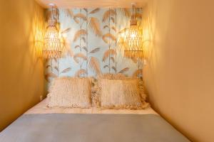 una camera con un letto con due cuscini sopra di Le Saint Victor Coeur de Cannes a Cannes
