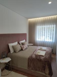 a bedroom with a large bed and a window at Suite na baixa do Porto in Porto