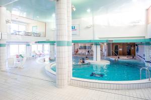 a large pool in a building with people in it at Hotel et Résidence Le Clos Cerdan in Mont-Louis