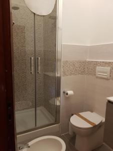 a bathroom with a toilet and a glass shower at Hotel La Torre in Cogoleto