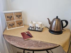 uma mesa com uma chaleira e duas canecas em La Bastide em Bédarrides