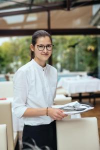 una mujer con gafas de pie junto a un mostrador en Hotel Rablanderhof, en Rablà