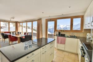 a kitchen with a table and a dining room with mountains at Topas 7 in Bettmeralp