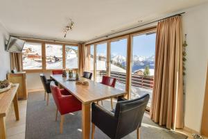 a dining room with a table and chairs and a large window at Topas 7 in Bettmeralp