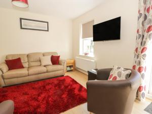 a living room with a couch and a red rug at Northolme in Filey