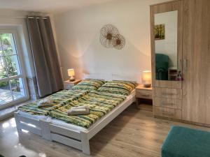a bedroom with a bed with a green comforter at Penzion Beskyd in Dolní Bečva