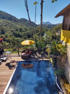 a pool on a deck with a view of the mountains at Pousada Bella Vista in Visconde De Maua
