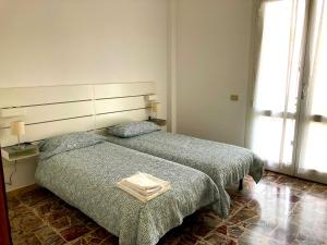 1 Schlafzimmer mit 2 Betten und einem großen Fenster in der Unterkunft Happy House Diano Marina in Diano Marina