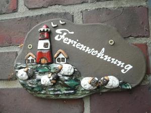 a sign with a lighthouse on a wall at Ferienwohnung Zum grünen Holz in Bohlenberge