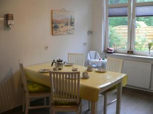 a dining room table with chairs and a yellow table cloth at Ferienwohnung Zum grünen Holz in Bohlenberge
