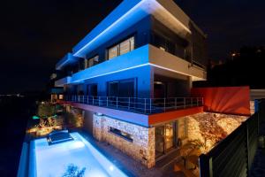 a house with a swimming pool at night at Olon Villa in Schinias