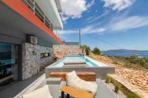 a house with a swimming pool on a hill at Olon Villa in Schinias