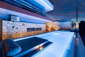 a swimming pool in a house at night at Olon Villa in Schinias