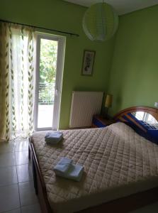 a bedroom with a bed with two towels on it at Evi's Apartment in Lefkada Town