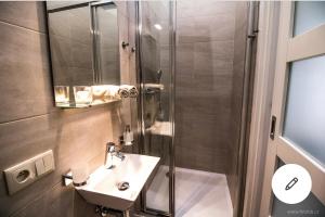 uma casa de banho com um chuveiro e um lavatório. em Romantic Apartment Petra - free parking Friday-Sunday em Praga