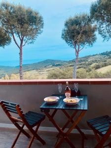 una mesa con dos platos de comida y copas de vino en Casa Jonorunn, en Nibbiaia