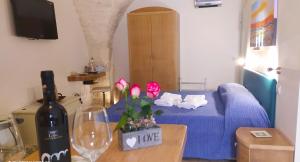 a living room with a blue bed and a bottle of wine at La Volta del Conte-Holiday Home Centro Storico in Cisternino