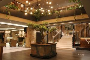 a lobby with a potted tree in the middle of a building at Hotel Anthidon Estate in Chalkida