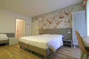 ロッカ・ピエトーレにあるHotel Veneziaのベッドルーム1室(ベッド1台付)が備わります。壁には絵画が飾られています。