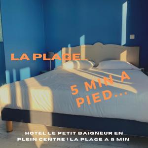 Hotel Le Petit Baigneur Palavas Plage في بالافاس ليه فلو: غرفة نوم بسرير مع جدار ازرق