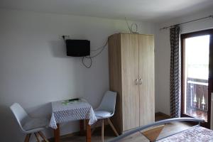 Zimmer mit einem Tisch, Stühlen und einem Schrank in der Unterkunft BOOA Rooms Irena in Bohinj