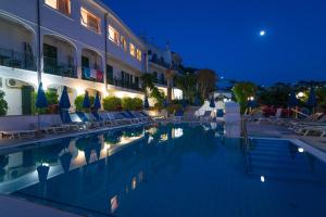 un hotel con piscina por la noche en Hotel Capizzo en Ischia