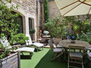 a patio with a table and chairs and plants at La Maison Bakéa in Cordes-sur-Ciel