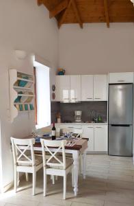 a kitchen with a table and chairs and a refrigerator at Aegean View Villas in Halki