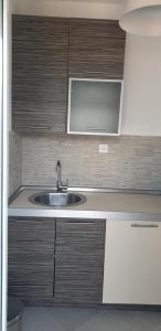 a kitchen with a sink and wooden cabinets at Apartments Scorpio in Kotor +60 photos