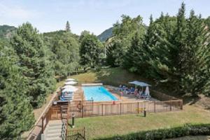 Hébergement Coup de Coeur في آكس ليه تيرم: مسبح كبير في ساحه فيها اشجار