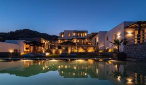 a house with a swimming pool at night at Maregold Mykonos Micro-Boutique Suites, Adults Only in Elia Beach