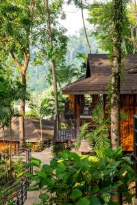 Baan Krating Khao Lak Resort - SHA plus في خاو لاك: منزل في وسط غابة فيها اشجار