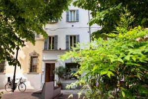 a white building with a bike parked in front of it at B&B AL DUCALE and APARTMENTS in Parma
