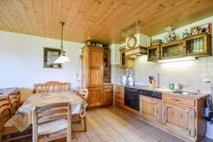 a kitchen with wooden cabinets and a table in it at Weisshorn 24 in Riederalp