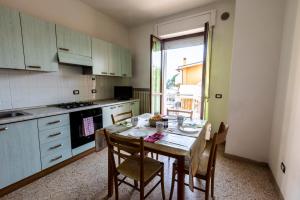 uma cozinha com uma mesa com cadeiras e uma janela em Edera Silvi Vacanza em Silvi Marina