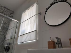 a bathroom with a window and a mirror and a sink at Little Blue House in Marsalforn