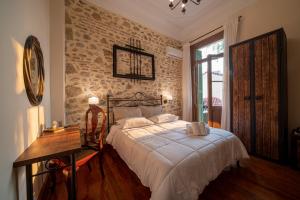 sypialnia z łóżkiem i ceglaną ścianą w obiekcie Beautiful City Suites w Atenach