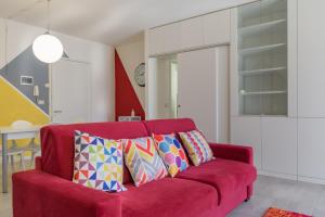 a red couch with colorful pillows in a living room at I SOLI in Verona