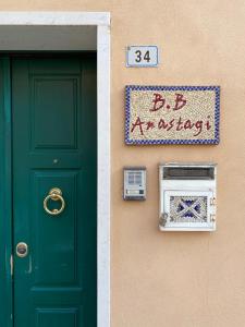una puerta verde y un cartel junto a una casa en B&B Anastagi, en Rávena