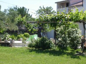 un jardin avec une pergola et quelques buissons dans l'établissement Studio apartment in Funtana with balcony, air conditioning, WiFi, washing machine 4982-2, à Funtana